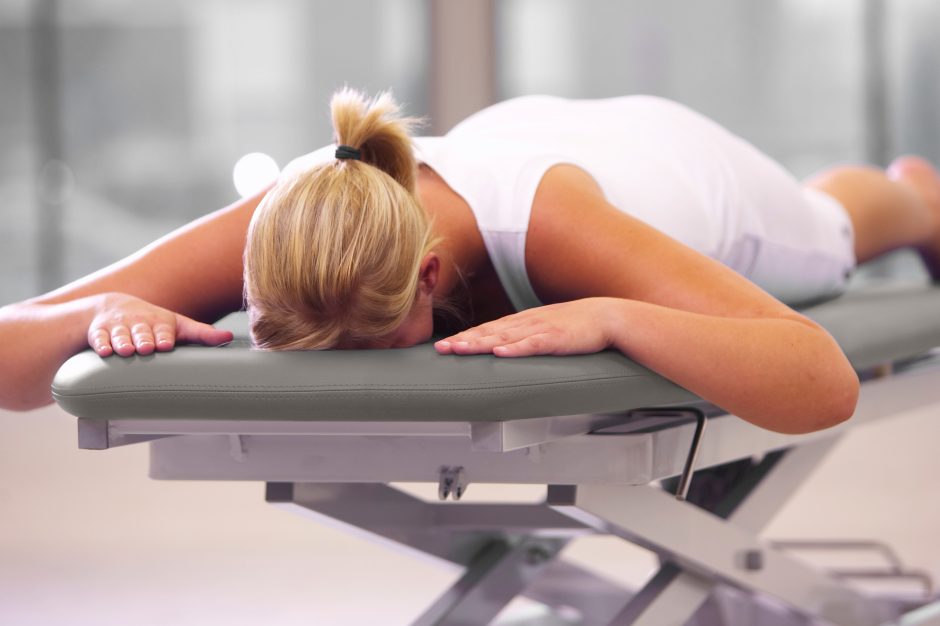Patient positioned on aXionXelect electric treatment table in clinical setting